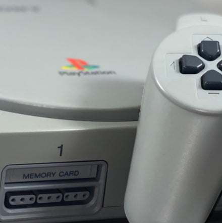 PlayStation Videospiel Konsole von vorne mit einem Dualshock Controller